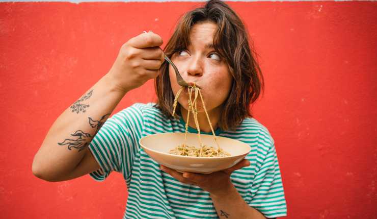 Ragazza che mangia la pasta